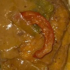 a close up of food on a plate with gravy and vegetables in it