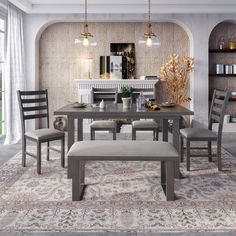 a dining room table with four chairs and a bench in front of a fireplace area