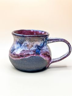 a purple and blue mug sitting on top of a table