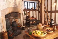 a rustic living room with stone fireplace and wooden table topped with bowls of fruit on it