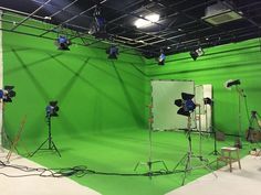 a green screen studio with lights and lighting equipment