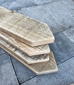 three wooden boards stacked on top of each other in the middle of a sidewalk area