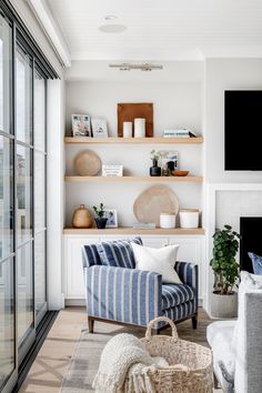 a living room filled with furniture and a flat screen tv mounted on a wall above a fire place