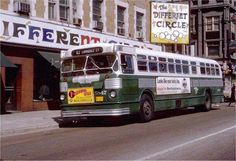 an old bus is parked on the side of the road in front of a building