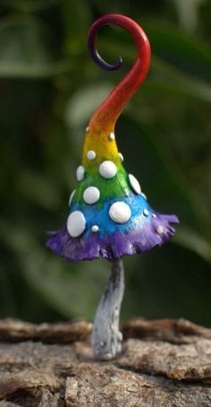 a small colorful mushroom sitting on top of a tree stump