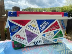 a cooler bag sitting on top of a table covered in different types of stickers