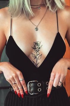 a woman wearing a black dress with a rose tattoo on her chest and two rings around her waist