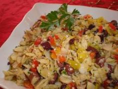 a white plate topped with rice and vegetables on top of a red cloth covered table