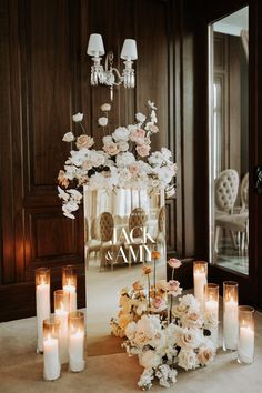 a table with candles and flowers in front of a mirror that says jack & sam