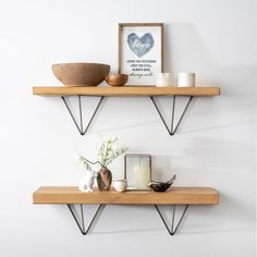 two wooden shelves with metal brackets on the top and one shelf holding candles, vases and other items