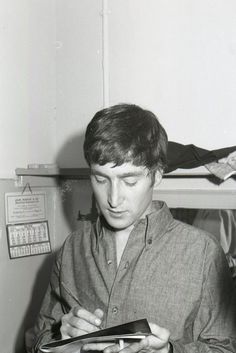 black and white photograph of a young man looking at something on his tablet computer while sitting in front of him