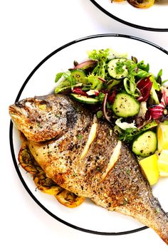 a white plate topped with fish and vegetables