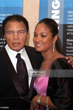 a man and woman standing next to each other in front of a sign with words on it