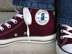 someone's feet wearing converse shoes with the doctor who logo on them and white laces