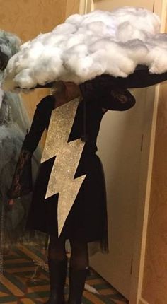 a woman is dressed up as a wizard with clouds on her head and lightning bolt