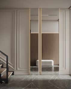 an empty room with marble floors and white walls, along with some stairs leading up to the second floor