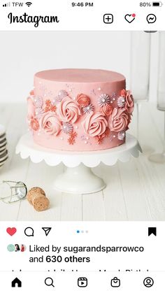 a pink cake sitting on top of a white table