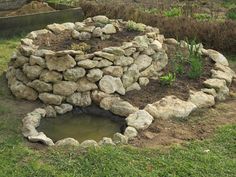 there is a small pond in the middle of this rock garden wall that has been built into it