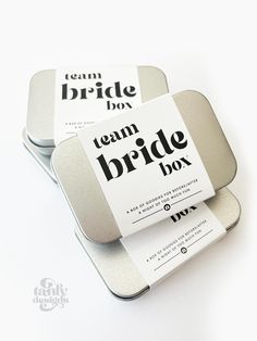 two square tins with the words team bride boy on them sitting next to each other