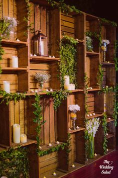 wooden shelves with candles, flowers and greenery on them are arranged in order to display the wedding bouquets