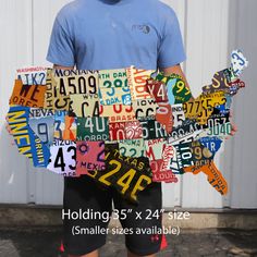 a man standing in front of a white building with lots of license plates on it