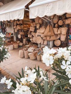 an outdoor market with lots of baskets and flowers