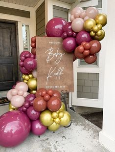 a welcome sign surrounded by balloons in front of a house