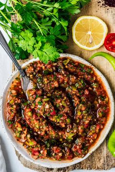 a bowl filled with beans and vegetables next to sliced limes