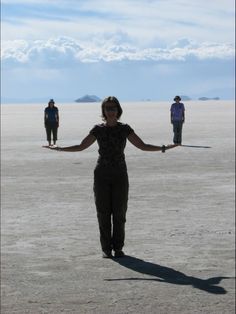 a woman standing in the middle of a desert