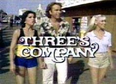 three women and a man walking down the street in front of a sign that says three's company