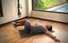 a man is laying on the floor in front of a window and stretching his legs