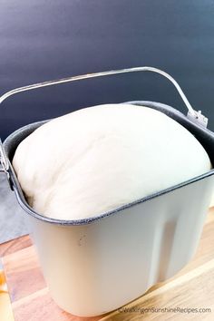 a bucket filled with white bread sitting on top of a wooden table