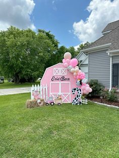 a pink barn decorated with balloons and farm animals