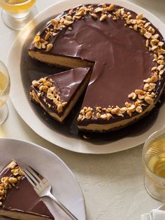 a chocolate cheesecake with walnuts on top and one slice missing from the cake