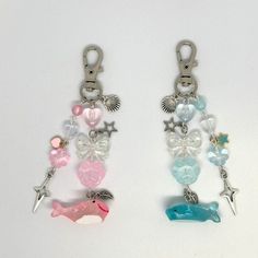 two key chains with charms on them sitting next to each other in front of a white background