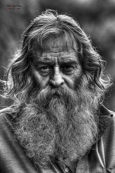 black and white photograph of an old man with long hair