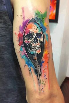 a person with a colorful tattoo on their arm and the skull is painted in watercolor