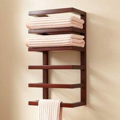 a towel rack with three towels hanging on it's sides and two folded ones in the middle