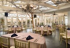 a dining room with tables and chairs set up for an event or function in front of large windows