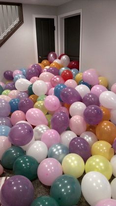 a room filled with lots of balloons in the middle of floor to ceiling carpeting