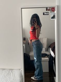 a woman is taking a selfie in the mirror with her cell phone while wearing jeans