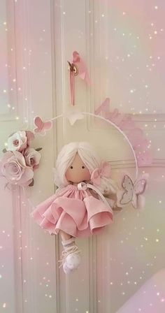 a doll hanging from the side of a white door with pink flowers and butterflies on it