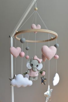 a mobile with hearts, an elephant and a star hanging from it's side