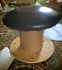 a mushroom like object sitting on top of a wooden stand in front of a rug