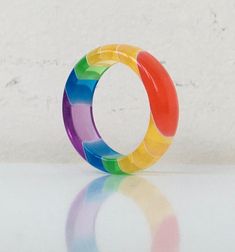 a multicolored ring sitting on top of a white table next to a wall