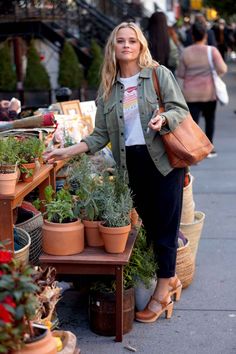 Reese Witherspoon looks cute and casual in an army green utility jacket, black pants, graphic tee and cognac accessories. Warm Autumn Color Palette, Spring Jacket Outfit, Winter Fall Outfits, Utility Jacket Outfit, Green Jacket Outfit, Reese Witherspoon Style, Autumn Color Palette, Fashion Makeover, Gamine Style