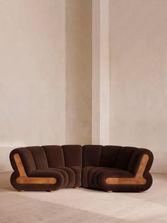 a brown couch sitting on top of a white floor next to a tall column in a room