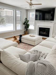 a living room filled with furniture and a flat screen tv mounted on the wall above a fireplace