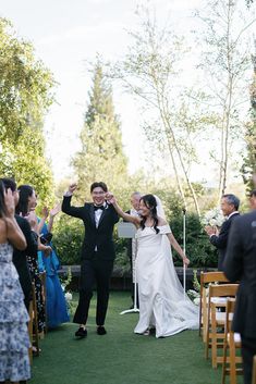 a bride and groom walking down the aisle after their wedding ceremony at an outdoor venue