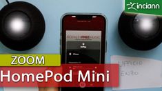 a person holding a cell phone next to two speakers with the words zoom home pod mini on it